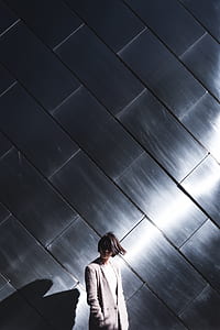 woman wearing gray coat standing near wall thumbnail