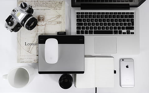 gray and black DSLR camera near Apple Magic Mouse and MacBook Pro thumbnail