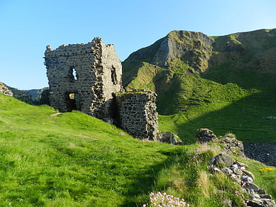 gray concrete ruins on green grasses thumbnail