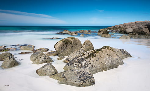 rock on seashore near body of water thumbnail