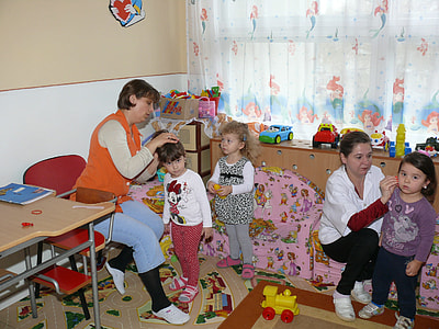 woman sitting on sofa while touching girl near window curtain thumbnail