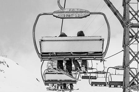 grayscale photography of two persons riding on cable car thumbnail