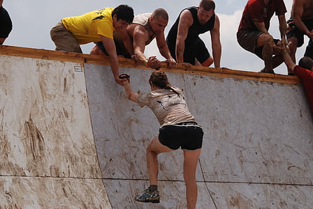 woman climbing on wall and two man helping thumbnail