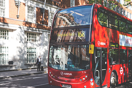A classic red London bus sits in dappled sunlight on a road in Central London, image captured with a Canon DSLR thumbnail