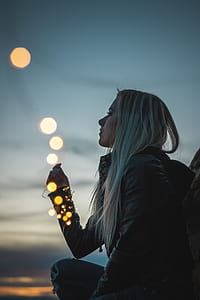 girl kneeling with LED strip lights on wrapped on right hand during golden time thumbnail