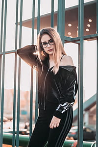 photo of woman wearing black jacket leaning on metal fence thumbnail