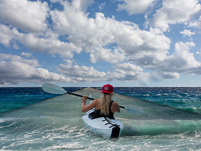 woman wearing black racerback tank top on white kayak under white clouds thumbnail