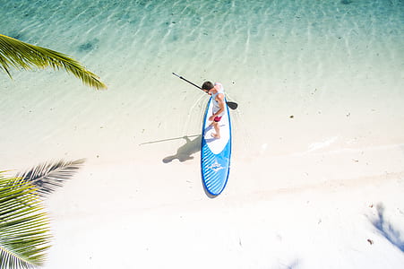 aerial photography of man on paddle board on shore thumbnail
