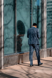 man wearing blue dress shirt and pants near window glass panel thumbnail