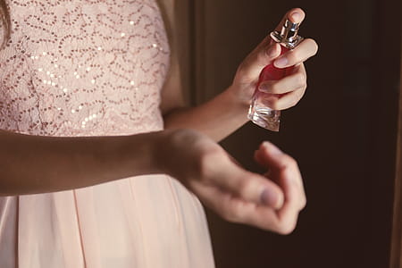 Beautiful young woman with bottle of perfume at home, closeup thumbnail