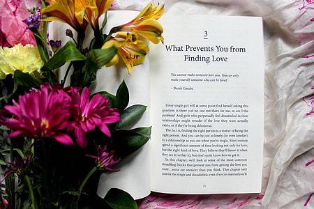 white bookpage near pink and yellow petaled flowers thumbnail