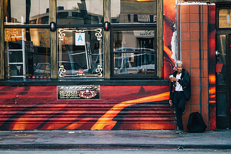 man leaning in red concrete wall thumbnail