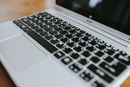 Silver laptop with various items on a table thumbnail
