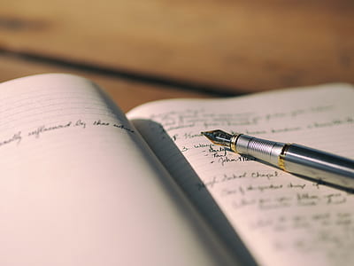 silver ballpoint pen on top of white notebook page thumbnail