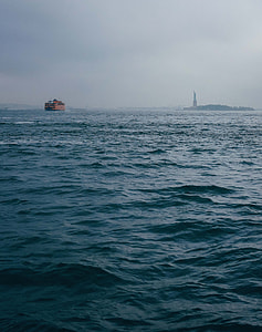 brown boat on body of water during foggy weather thumbnail