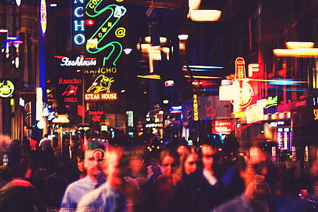 time lapse photography of crowd of people walking near lighted buildings thumbnail