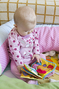 closeup photo of baby in pink pajama top and pants holding dog printed toy thumbnail
