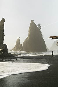 man standing on seashore in front of body of water thumbnail