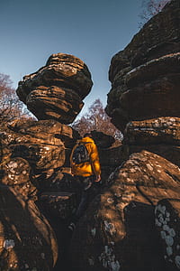 person standing under boulder thumbnail