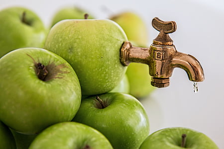close-up photography of granny Smith apple with brass-colored faucet thumbnail