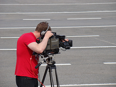 man holding video recording camera on gray concrete road at daytime thumbnail