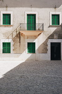 gray concrete building with green doors and windows thumbnail