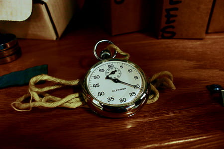 White Pocket Watch With Gold-colored Frame on Brown Wooden Board thumbnail