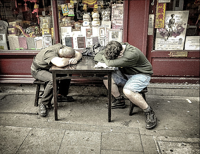 two men sleeping on table outside store thumbnail