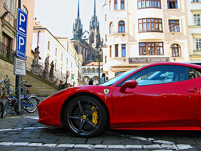 red Ferrari sports coupe parked on bricked pavement at daytime thumbnail