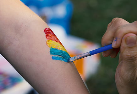 person painting color on person arm thumbnail