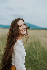 woman wearing white long-sleeved shirt standing on the grass thumbnail