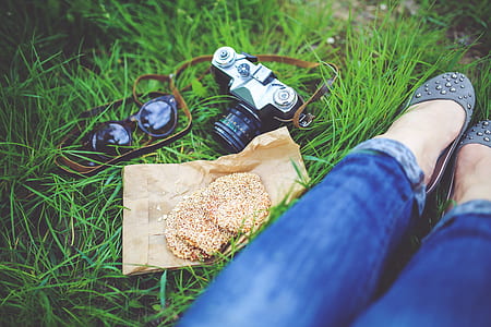 black and silver DSLR camera near in women's feet thumbnail