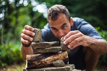 man wearing shirt and holding two stones thumbnail