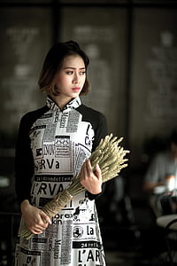 woman wearing white and black collared dress holding white flower thumbnail