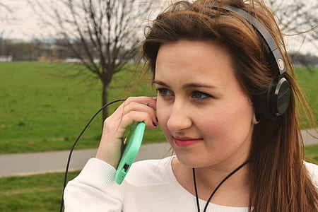 woman wearing black corded headphones white holding smartphone thumbnail
