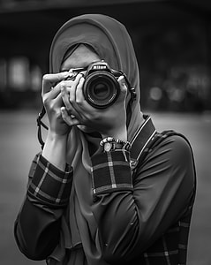 grayscale photography of woman taking photo using Nikon camera thumbnail