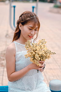 Woman Wearing White Lace Dress Holding Yellow Flower Bouquet thumbnail