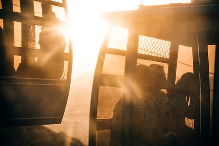three people on cable cart during sunset thumbnail