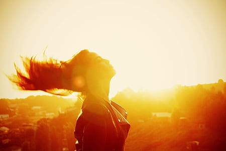 sepia photo of woman waving hair with distance at trees thumbnail