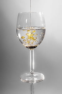 clear wine glass filled with clear and yellow liquid thumbnail