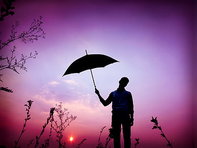 purple filter silhouette photography of man holding umbrella thumbnail