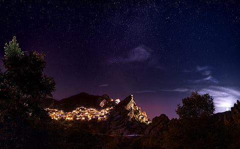 town lights near mountain during nighttime thumbnail