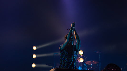 man performing on stage at night time thumbnail
