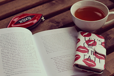 white ceramic teacup beside opened book and white and red lips print long flip phone case thumbnail