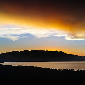 silhouette photo of mountain range near body of water thumbnail