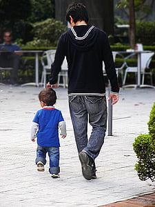 man walking on street beside child thumbnail