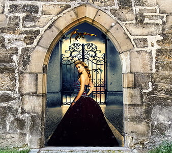 woman in black dress standing in front of castle gate thumbnail