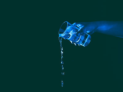 person holding a glass cup of water pouring it down thumbnail
