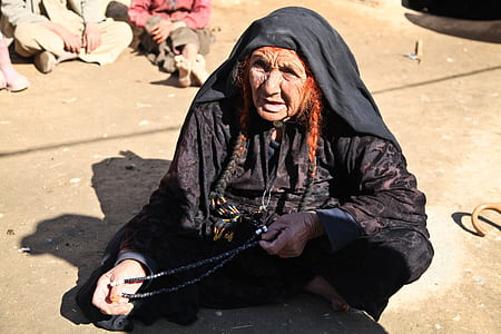 woman sitting holding beaded necklace thumbnail