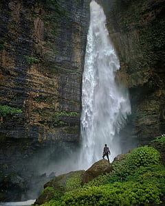 person standing in front of waterfalls thumbnail
